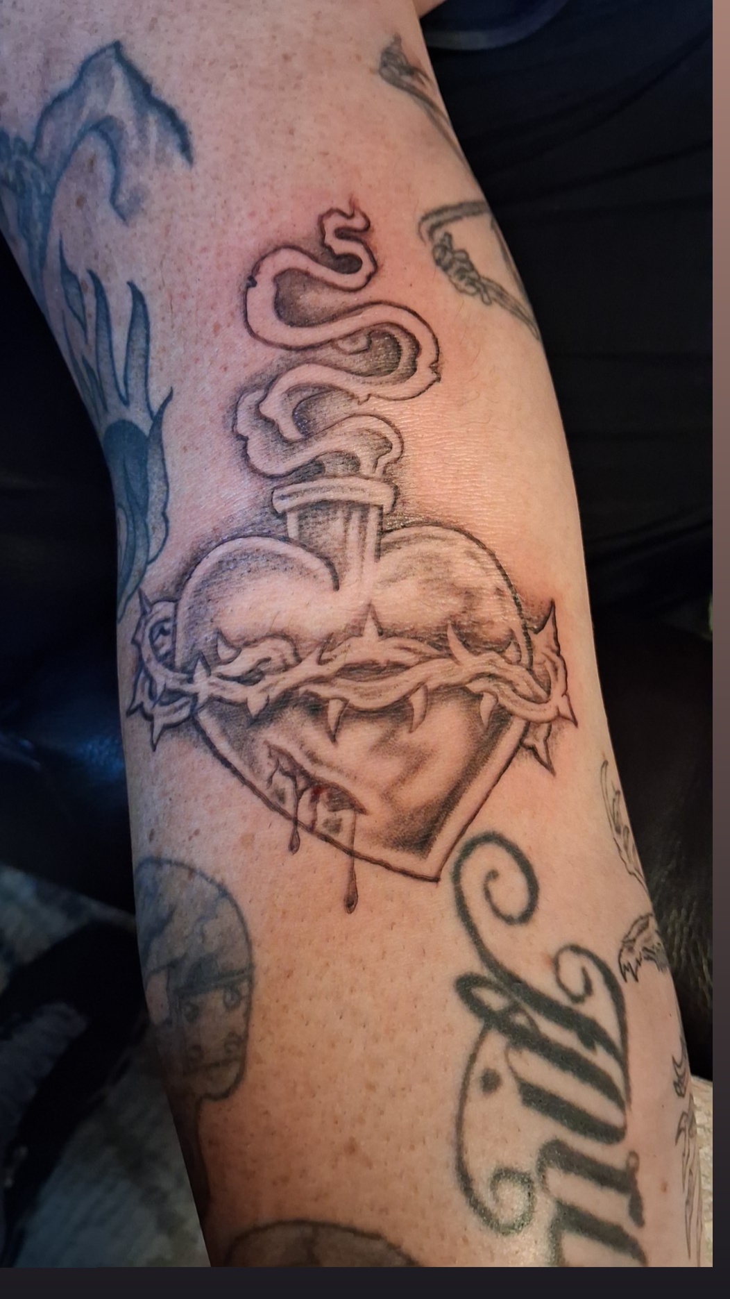 Sacred heart with dagger and crown of thorns arm tattoo