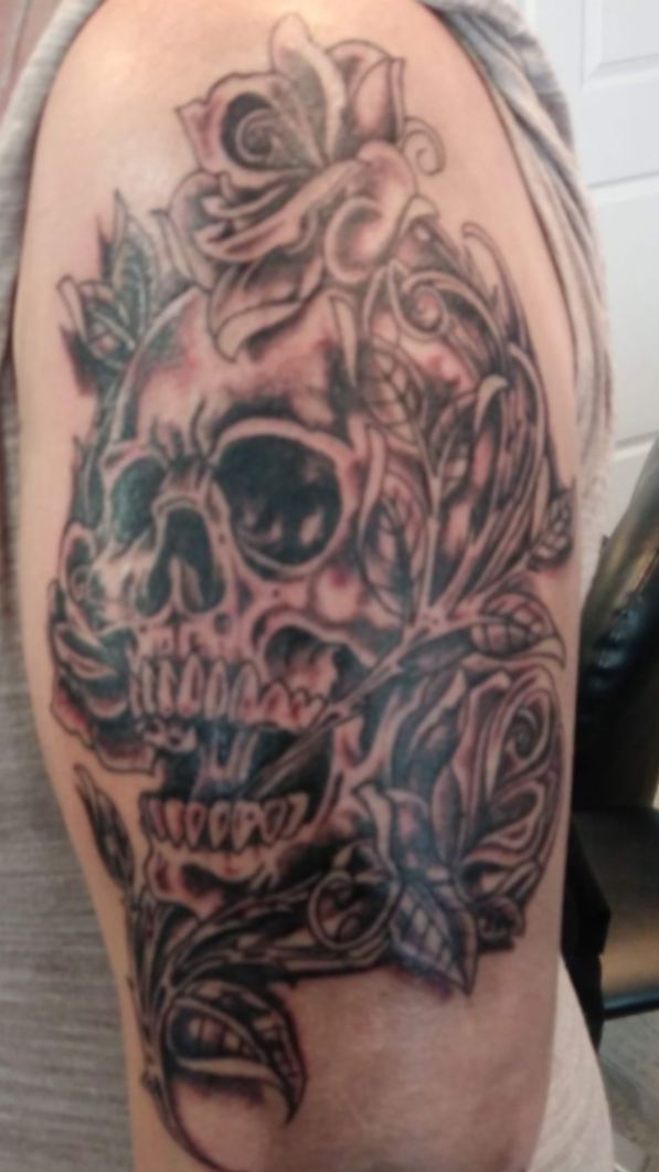 Black & gray skull with roses arm tattoo