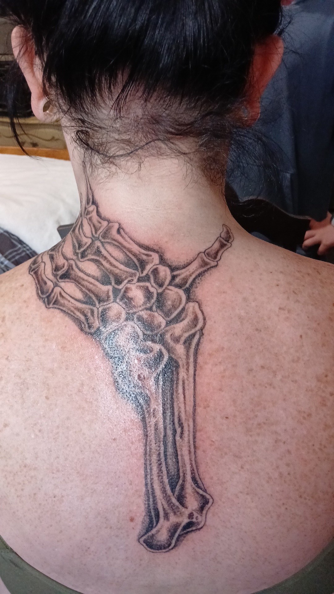 Skeleton hand and bone neck tattoo