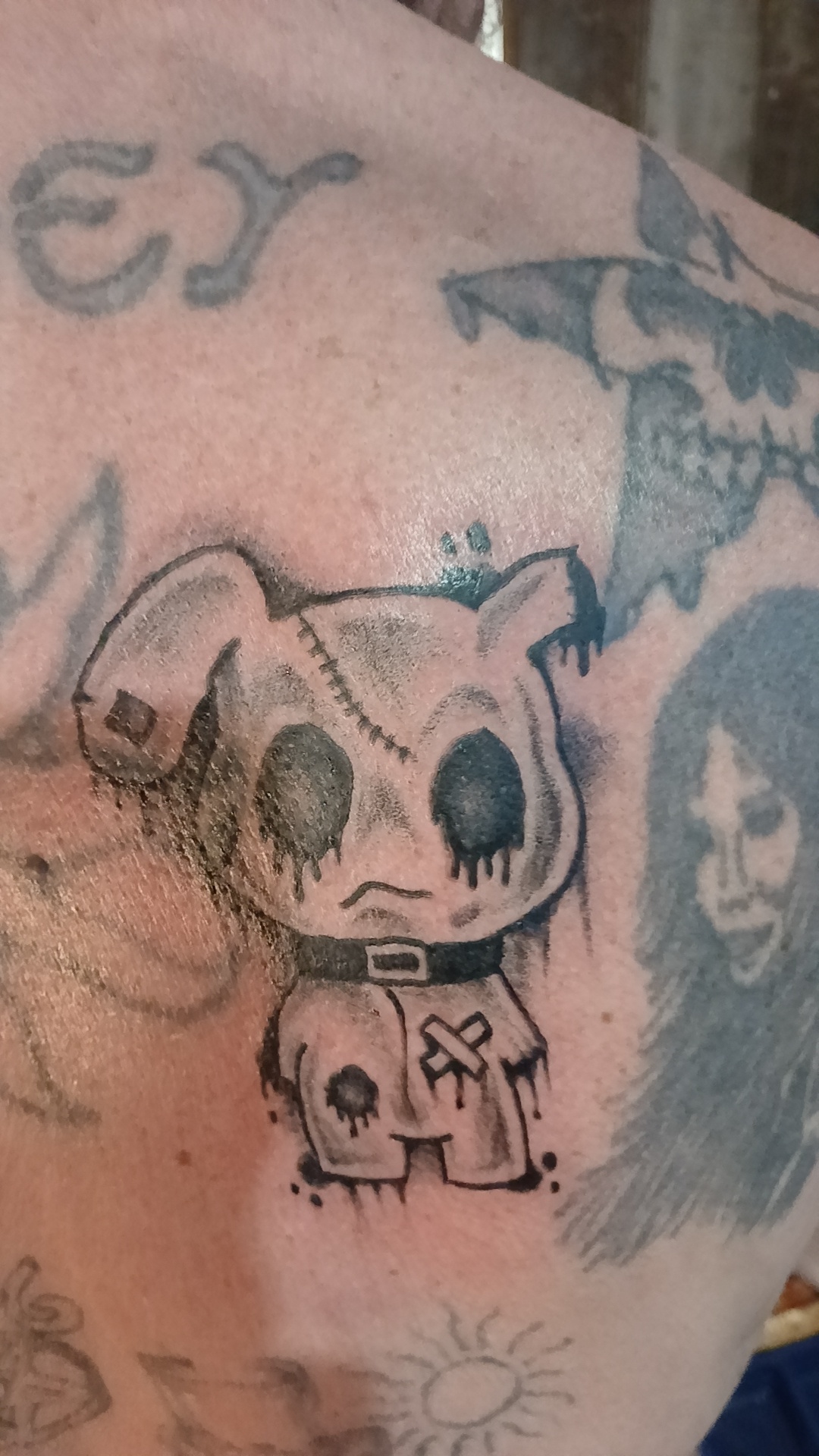 Creepy cartoon bunny priest chest tattoo